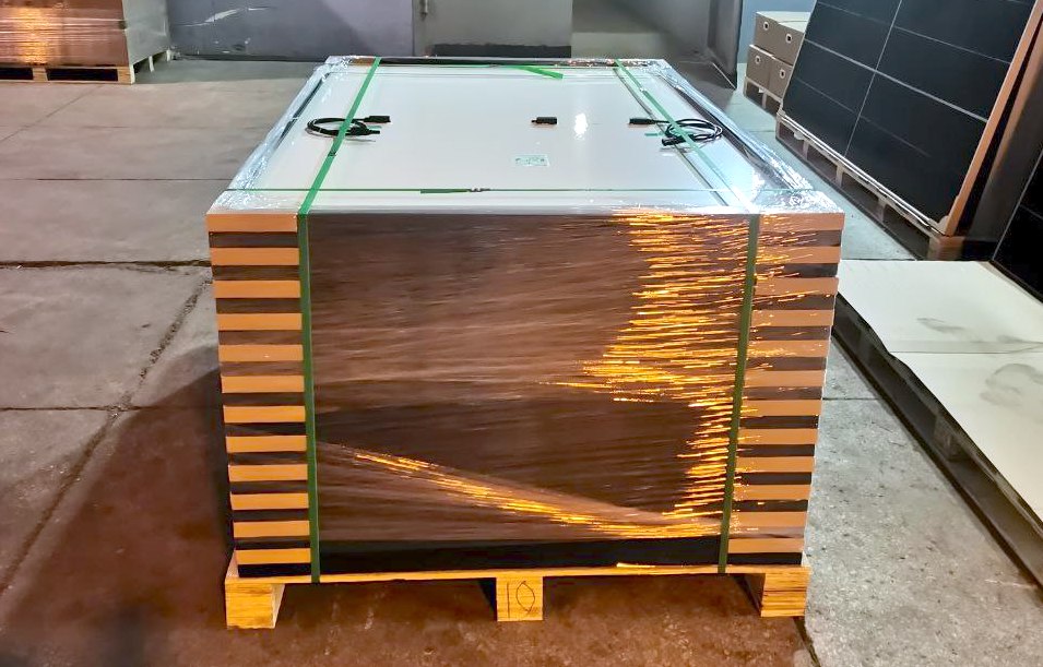 Verpackte Solarpanels, die aufeinander gestapelt sind, mit speziellen Eckenprotektoren. Das gesamte Paket ist in Klarsichtfolie für zusätzlichen Schutz eingewickelt.