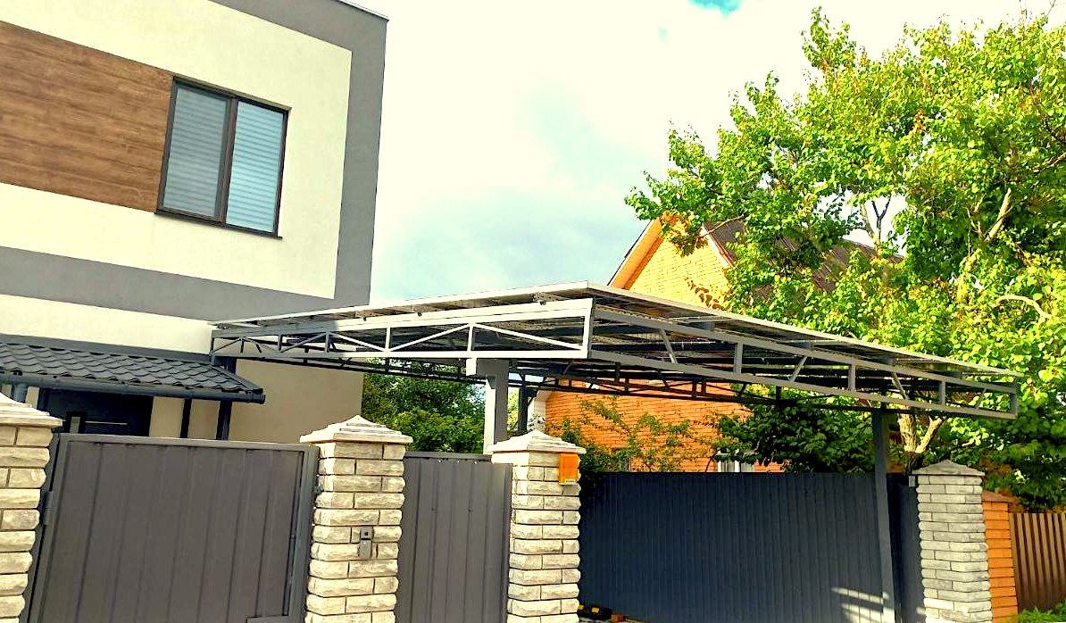 Utsikt fra bakken av en carport laget av solcellepaneler