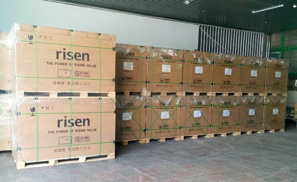 Fabrika kutularında paketlenmiş güneş panelleri, iki sıra halinde istiflenmiş.